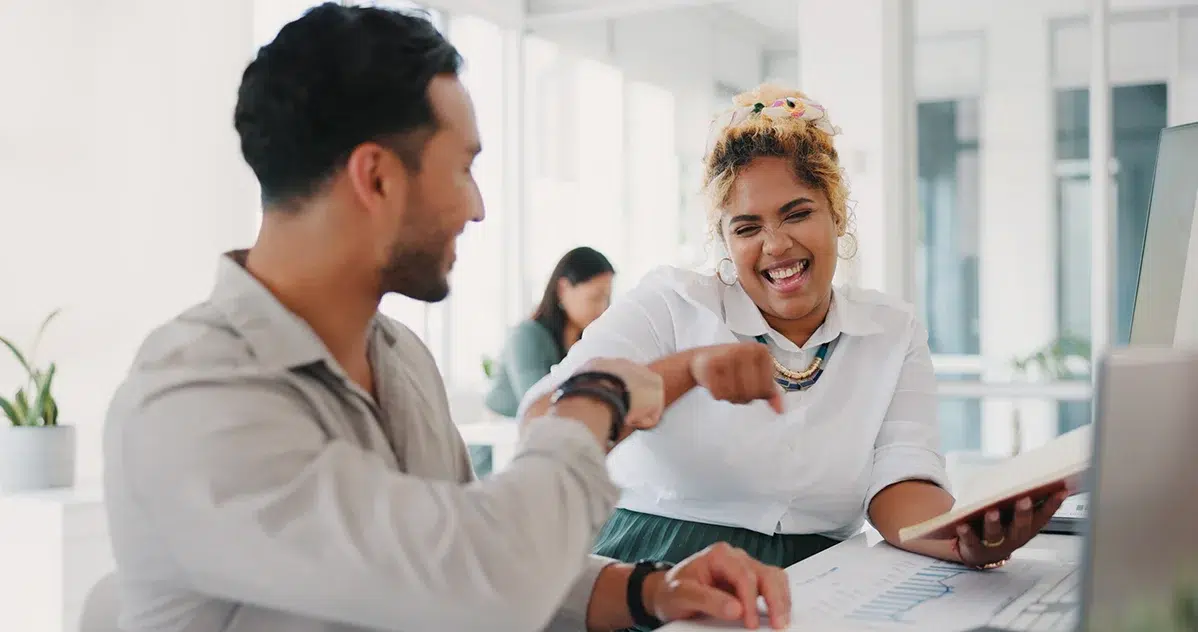 Employees celebrating tax free benefits at desk
